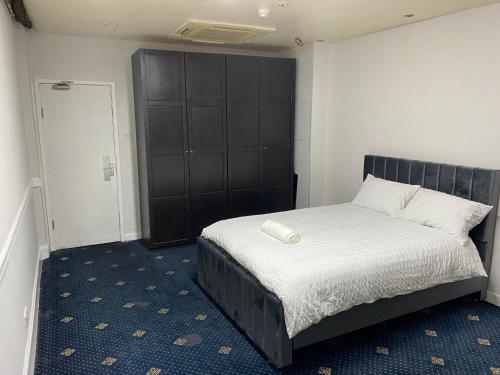 Schlafzimmer mit einem Bett mit einem schwarzen Kopfteil in der Unterkunft Cozy spacious double room rm 8 in Oldham