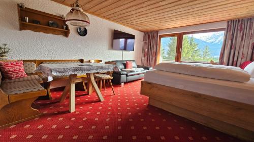 um quarto com uma cama, uma mesa e um sofá em Berghof Mehlan em Fischen