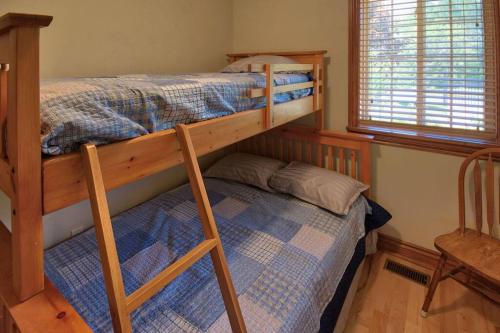 1 Schlafzimmer mit 2 Etagenbetten und einem Stuhl in der Unterkunft Sunset Getaway, Cozy 5 people, 2 min to beach! in Lambton Shores
