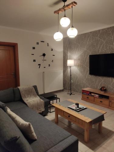 a living room with a couch and a clock on the wall at Rania's house in Aigio