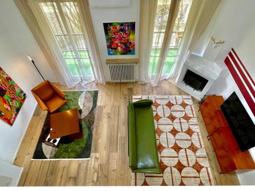 vista sul soffitto di un soggiorno con sedia verde di BORGO TICINO SUITE Attico di Lusso con Terrazzo e Parking Privato a Pavia