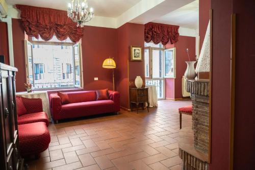 a living room with red chairs and a fireplace at Imperial GuestHouse in Rome