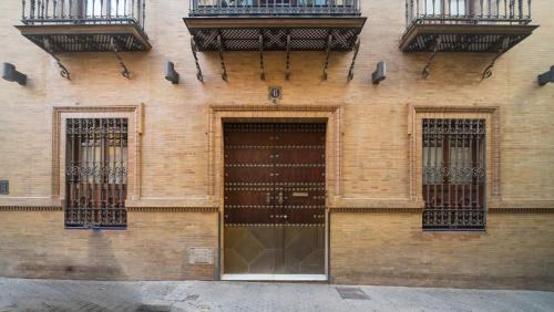 ein Backsteingebäude mit zwei Türen und zwei Balkonen in der Unterkunft EXCLUSIVE TRIPLEX WITH PRIVATE TERRACE in Sevilla
