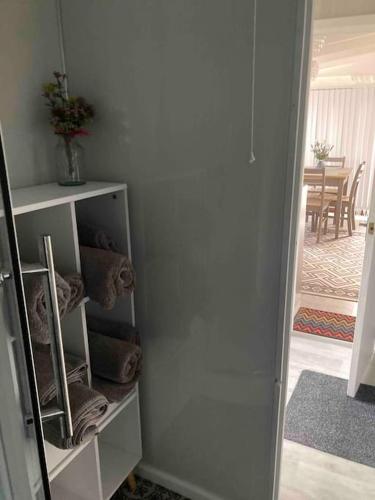 a room with a white cabinet with towels in it at 7F Cwtch Cymru Lodge, Caer Beris Holiday Park - no commercial vehicles permitted on site in Builth Wells