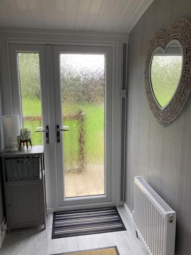 a room with a door with a window and a mirror at 7F Cwtch Cymru Lodge, Caer Beris Holiday Park - no commercial vehicles permitted on site in Builth Wells