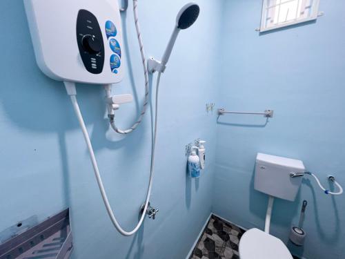 a blue bathroom with a toilet and a shower at HH Homestay Dungun in Kampong Gok Kapor