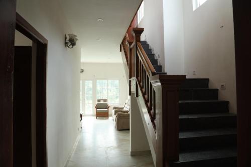 a hallway with stairs in a house at Pear Tree Luxe Entire 3BHK Mansion in Kotagiri