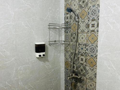 a shower with a soap dispenser on a wall at 美菊民宿 停車方便 市中心 in Chaozhou
