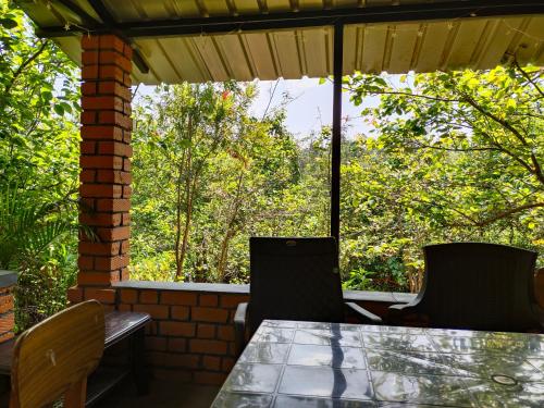 een tafel en stoelen op een patio met bomen bij Pear Tree Luxe Entire 3BHK Villa - Only For Family in Kotagiri