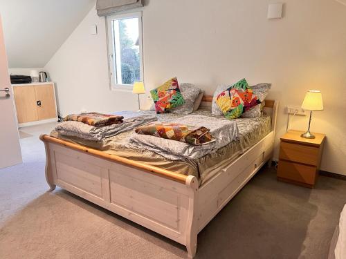 ein Schlafzimmer mit einem Holzbett mit Kissen darauf in der Unterkunft Großes & Modernes Ferienhaus 2 Minuten von Meersburg Innenstadt in Meersburg