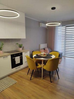 a kitchen and dining room with a table and yellow chairs at Nowy Apartament in Mińsk Mazowiecki