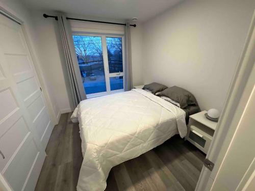 um quarto com uma cama branca e uma janela em One bedroom apartment - 1906 em Montreal