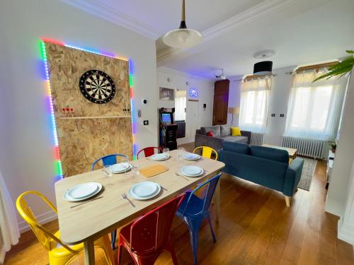 une salle à manger et un salon avec une table et des chaises dans l'établissement Maison 3ch - Cinéma - Game Room - Parking - Gare, à Amiens