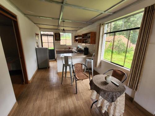 a kitchen with a table and chairs in a room at Casita Campestre Pitusiray in Calca