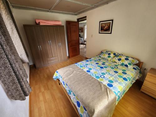 a bedroom with a bed and a wooden floor at Casita Campestre Pitusiray in Calca
