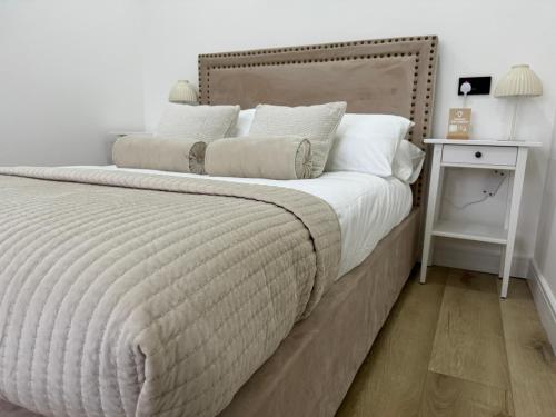 a bedroom with a large bed with a wooden headboard at Lux 1 Bed Flat - Free Parking in Oxford