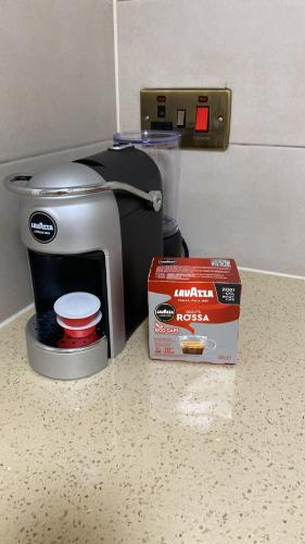 a coffee maker and a box on a counter at Leamington Park Studio with Parking in London