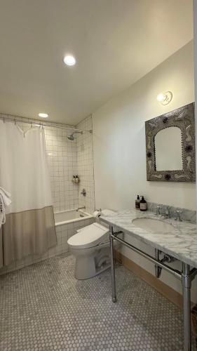 a bathroom with a toilet and a sink and a tub at The Parador in Santa Fe