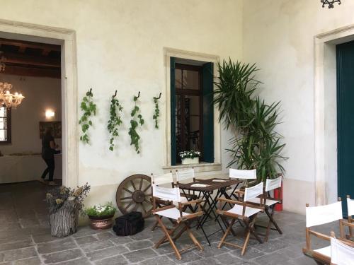 eine Terrasse mit einem Tisch, Stühlen und Pflanzen in der Unterkunft Agriturismo Barchessa in Este