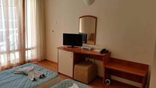 a bedroom with a desk with a television and a bed at Sem.hotel -Afrikana in Sveti Vlas