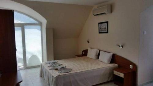 a bedroom with a bed with a large window at Sem.hotel -Afrikana in Sveti Vlas