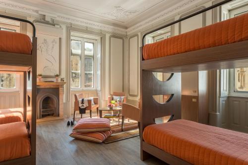 a bedroom with a bunk bed and a living room at Serenata Hostel Coimbra in Coimbra