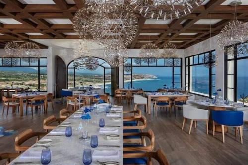 a dining room with tables and chairs and a chandelier at VISTA ENCANTADA AT HACIENDA ENCANTADA & SPA RESORT- apartment in Cabo San Lucas