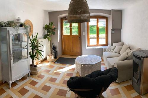 a living room with a couch and a table at Gîte Au Moulin de Bougnon Calme et Dépaysement en Haute-Saône in Bougnon