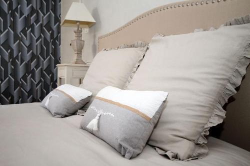 Una cama blanca con dos almohadas encima. en Gîte Au Moulin de Bougnon Calme et Dépaysement en Haute-Saône 