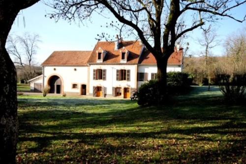 a large white house with a tree in the yard at Gîte Au Moulin de Bougnon Calme et Dépaysement en Haute-Saône in Bougnon