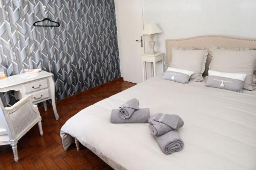 a bedroom with a white bed with towels on it at Gîte Au Moulin de Bougnon Calme et Dépaysement en Haute-Saône in Bougnon