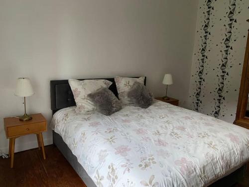 a bedroom with a bed with two tables and two lamps at Gîte Au Moulin de Bougnon Calme et Dépaysement en Haute-Saône in Bougnon