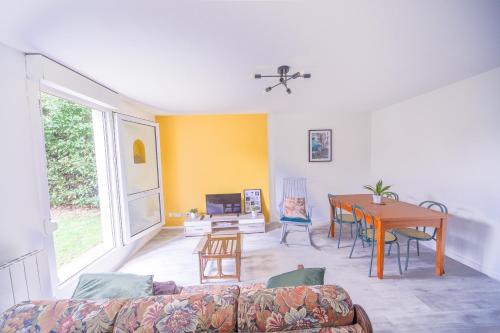 a living room with a couch and a table at Appartement en rez-de-chaussée avec jardin in Saint-Genis-Laval