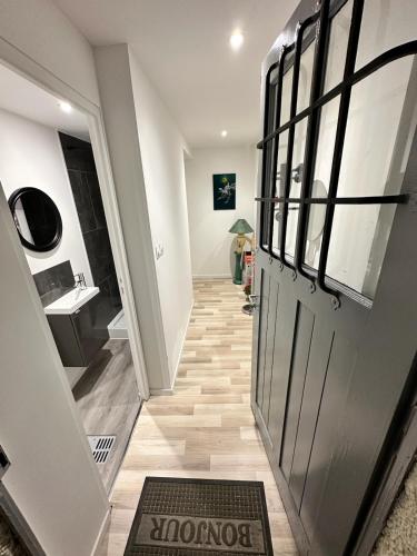 - un couloir avec une porte et un lavabo dans l'établissement Cosy citadin, à Mulhouse