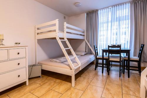 Apartment Dresden EG Links في درسدن: غرفة نوم مع سرير بطابقين وطاولة طعام