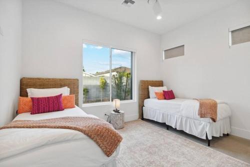 2 Betten in einem Zimmer mit Fenster in der Unterkunft Twin Sunsets Oasis with 2 Pools in Phoenix