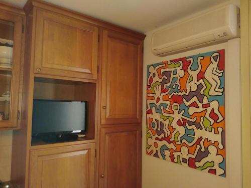 um quarto com uma televisão e um quadro na parede em Residenza Cornicello em Bardolino