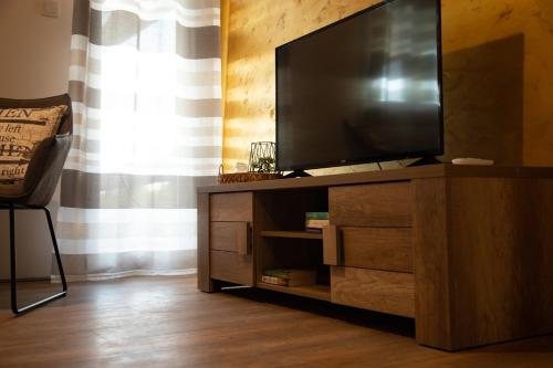 a flat screen tv sitting on top of a wooden entertainment center at Holiday home Sunce i Zora in Jalžabet