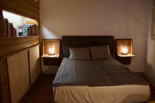 een slaapkamer met een bed met twee lampen aan beide zijden bij Tiny House: The Housje in Puerto de la Cruz