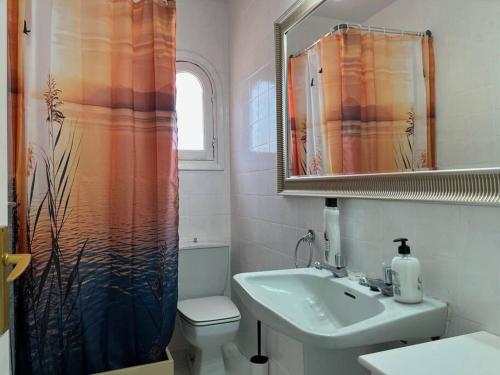 a bathroom with a sink and a shower curtain at Precioso Apartamento en Es Grau in Es Grau
