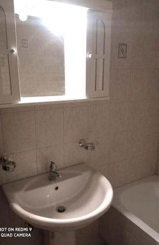 a bathroom with a white sink and a mirror at Agora Mansion in Arachova