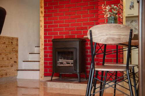 a red brick wall with a stove and a stool at Holiday home Sunce i Zora in Jalžabet