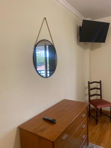 a mirror on a wall with a wooden table and a chair at Apartamento Costa Do Sol V in Funchal