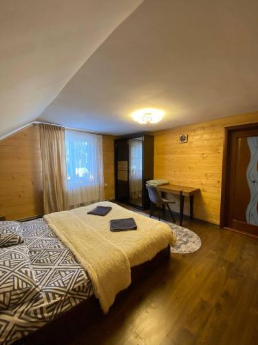 um quarto com uma cama grande e uma secretária em На Закуті em Mykulychyn