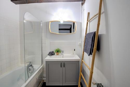 y baño con lavabo y espejo. en Cœur de Ville - T3 - 6 personnes - Arrivée Autonome en Tours