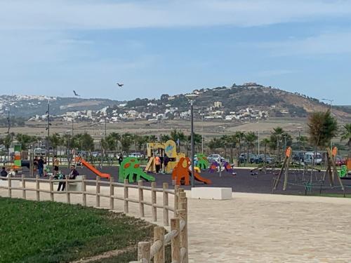 a park with a playground with slides and swings at Appartement familiale Amjad 3 chambres in Tangier