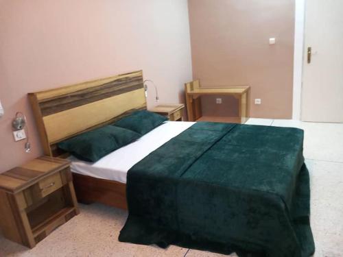 ein Schlafzimmer mit einem großen Bett und einer grünen Decke in der Unterkunft Résidence Wendyna in Ouagadougou