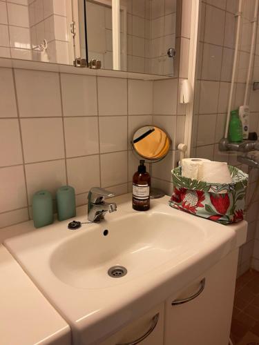 a white bathroom sink with a mirror and a bottle of soap at Jokioinen-Forssa apartment 48m2 in Jokioinen