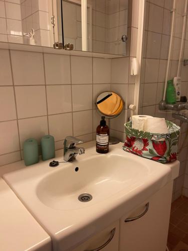 lavabo blanco con espejo y botella de jabón en Jokioinen-Forssa apartment 48m2, en Jokioinen