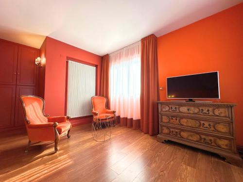 a living room with orange walls and a flat screen tv at Hotel Terme Delle Nazioni in Montegrotto Terme